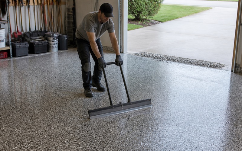 Worker scraping back cured flake with a wide flat blade held in both hands